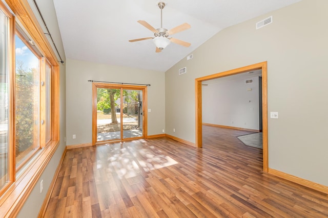 spare room featuring visible vents, baseboards, light wood-style flooring, and vaulted ceiling