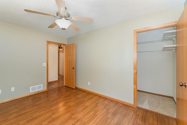 unfurnished bedroom with visible vents, ceiling fan, baseboards, light wood-style floors, and a closet