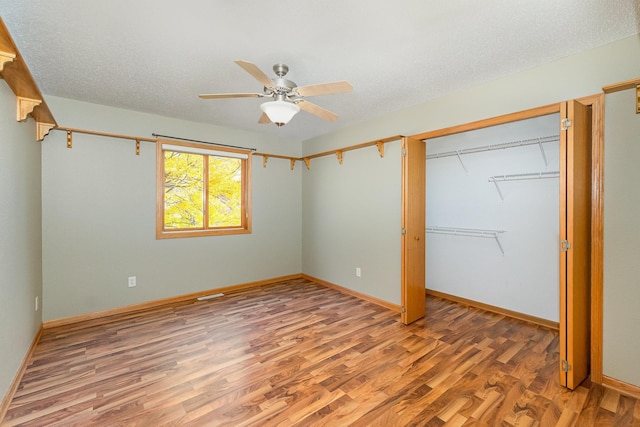 unfurnished bedroom featuring baseboards, ceiling fan, light wood-type flooring, a closet, and a textured ceiling