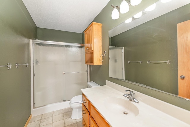 bathroom with tile patterned flooring, toilet, a stall shower, a textured ceiling, and vanity