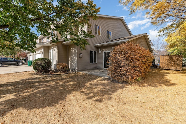 view of front of property with an attached garage, a patio area, and driveway