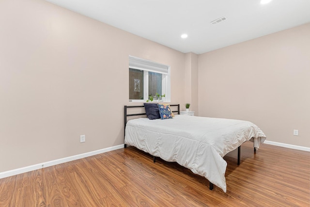 bedroom with visible vents, recessed lighting, baseboards, and wood finished floors