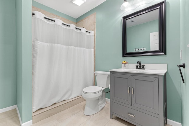 bathroom with vanity, a shower with shower curtain, toilet, and baseboards