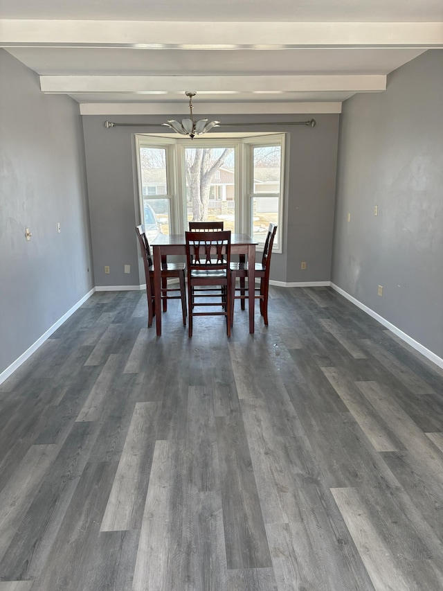 unfurnished dining area with beam ceiling, baseboards, and dark wood-style flooring