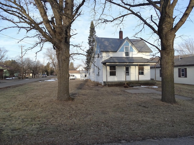 view of side of home featuring metal roof and a chimney