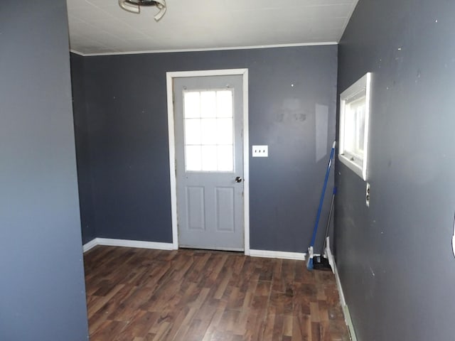 doorway featuring baseboards, wood finished floors, and crown molding