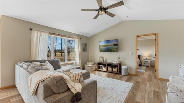 living room featuring vaulted ceiling, a ceiling fan, baseboards, and light wood finished floors