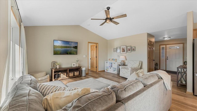 living area with light wood finished floors, a ceiling fan, and lofted ceiling