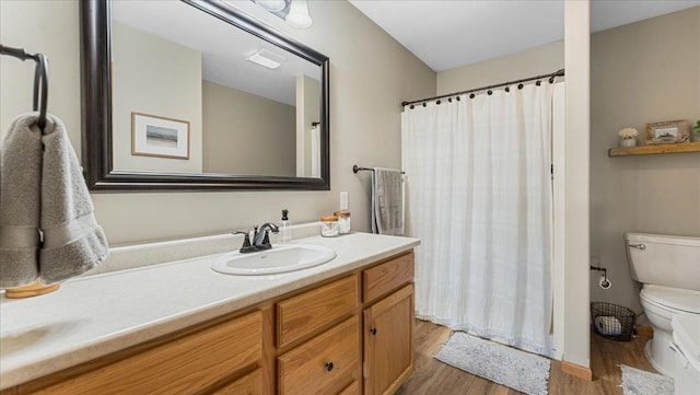 full bathroom with visible vents, toilet, a shower with curtain, wood finished floors, and vanity