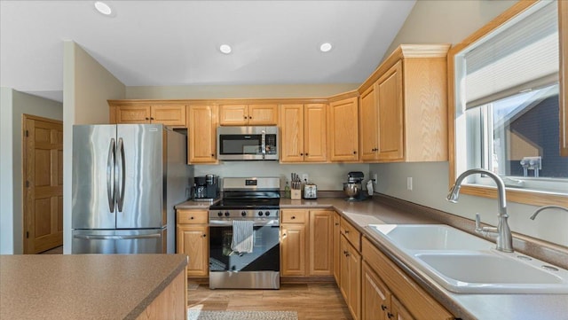 kitchen featuring light wood finished floors, recessed lighting, a sink, light brown cabinetry, and stainless steel appliances