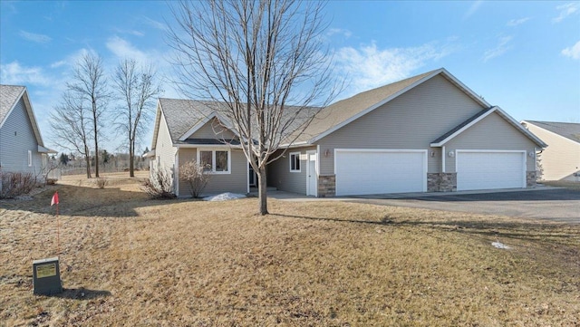 single story home featuring a garage, stone siding, and driveway