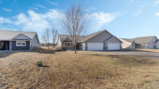 single story home featuring a garage and aphalt driveway