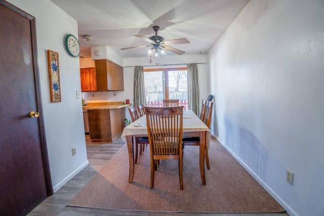 dining room with baseboards, a ceiling fan, and wood finished floors