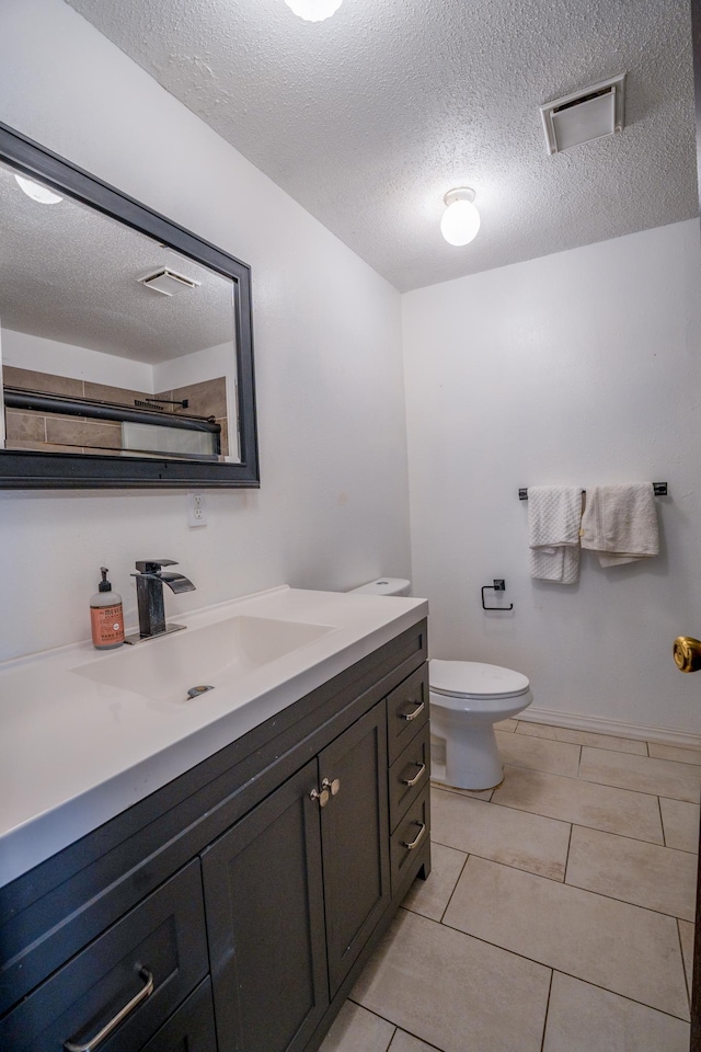 bathroom with vanity, toilet, visible vents, and a textured ceiling