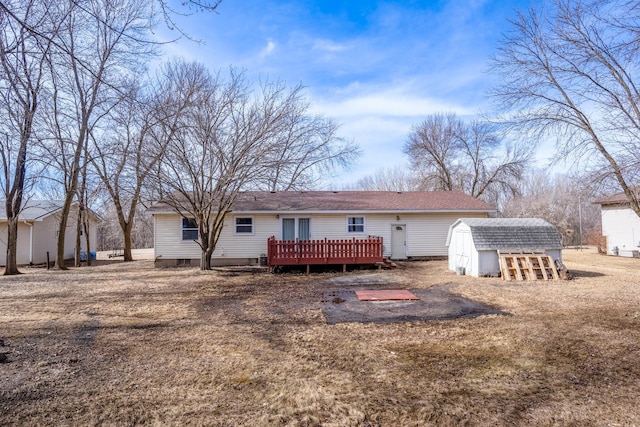 rear view of property with a deck, an outdoor structure, and a storage shed