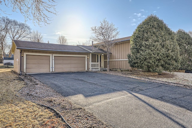 view of front of home with aphalt driveway, a garage, and board and batten siding