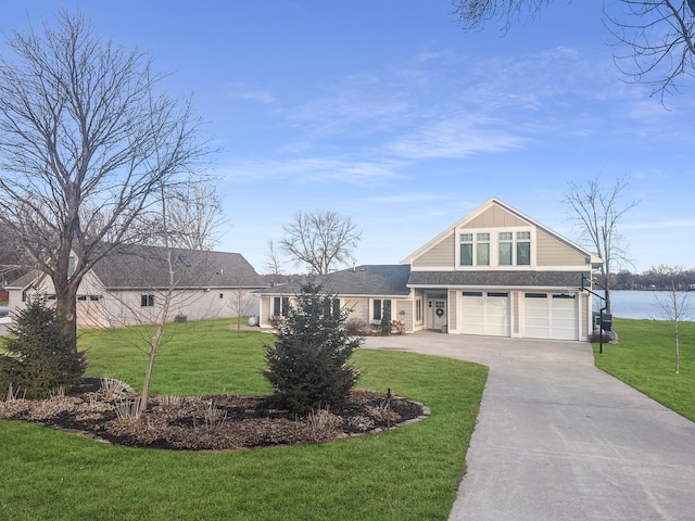 view of front of house featuring a garage, concrete driveway, and a front lawn