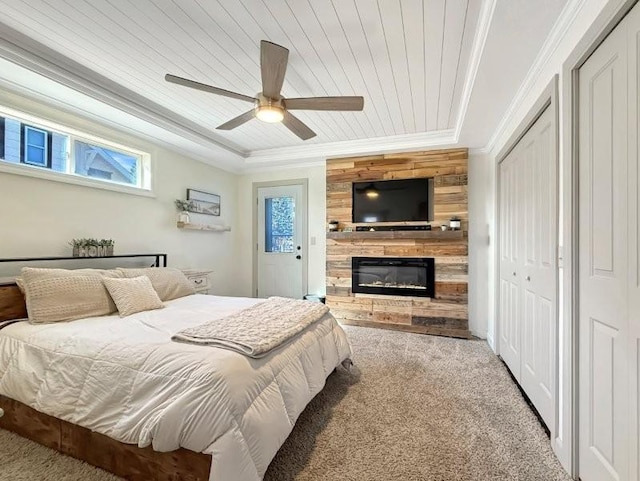 bedroom with a glass covered fireplace, wooden ceiling, carpet floors, and ornamental molding