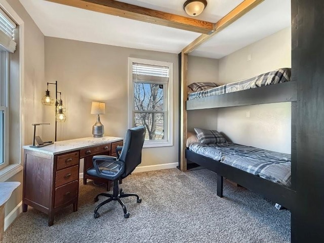 carpeted bedroom with baseboards and beam ceiling