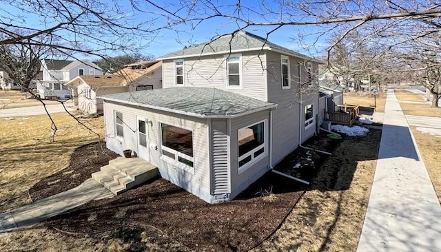 view of side of home featuring roof with shingles