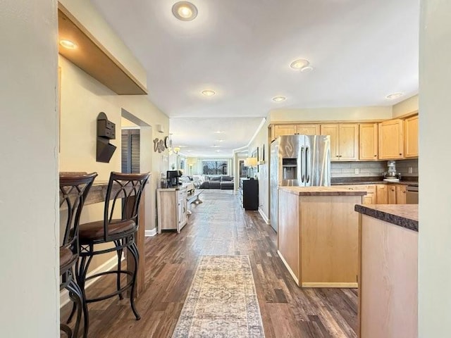 kitchen featuring backsplash, light brown cabinets, dark wood finished floors, open floor plan, and stainless steel refrigerator with ice dispenser