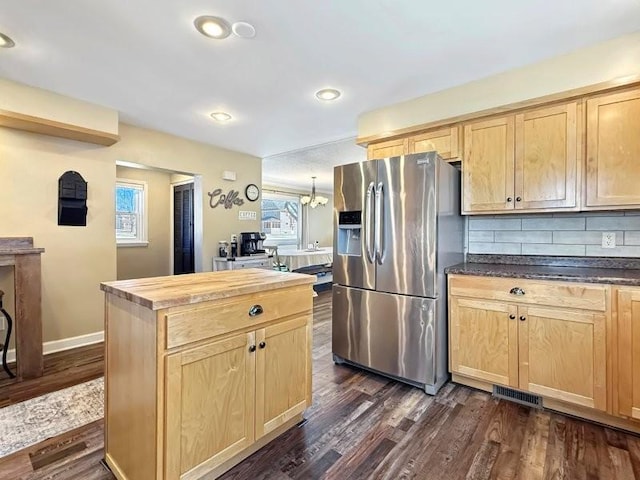 kitchen featuring visible vents, stainless steel fridge, dark wood-style floors, and light brown cabinets