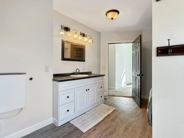 bathroom with vanity, wood finished floors, and baseboards