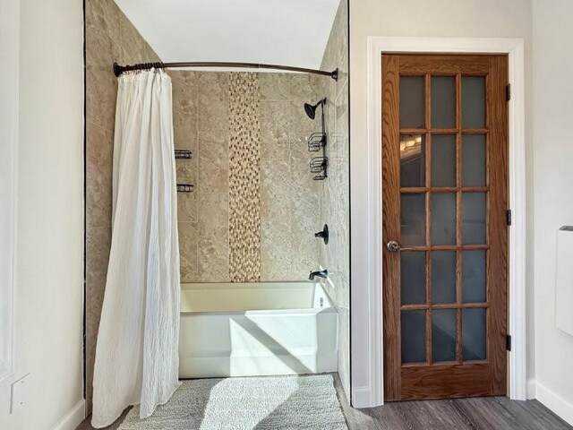 bathroom featuring wood finished floors and shower / bath combo