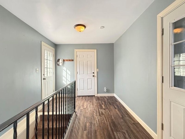 hallway with baseboards and dark wood-type flooring