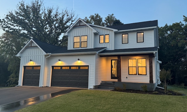 modern inspired farmhouse with a front lawn, board and batten siding, and driveway