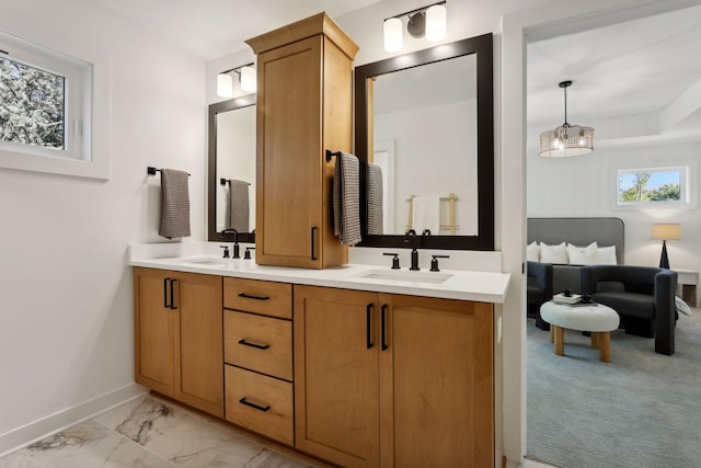full bath with baseboards, a sink, marble finish floor, and double vanity