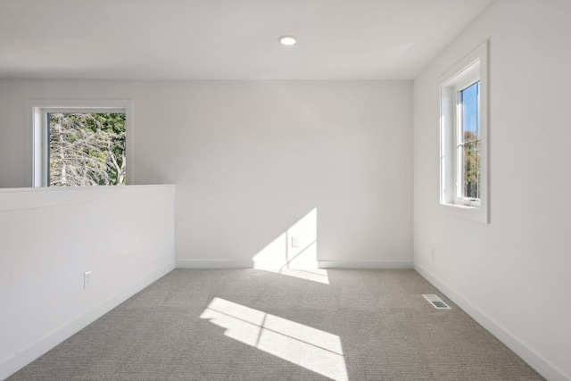 carpeted spare room featuring recessed lighting, visible vents, and baseboards