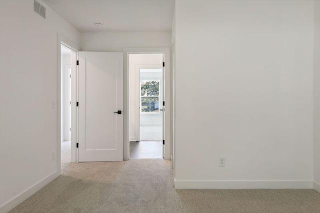 empty room featuring baseboards, carpet flooring, and visible vents
