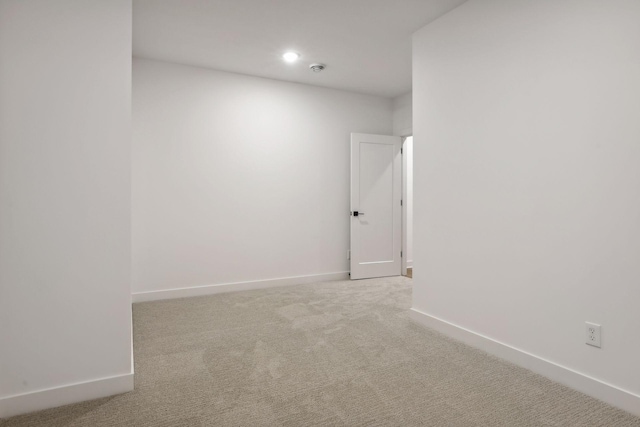spare room featuring baseboards, recessed lighting, and light colored carpet