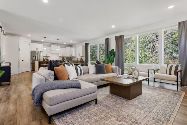 living room with light wood-type flooring and recessed lighting