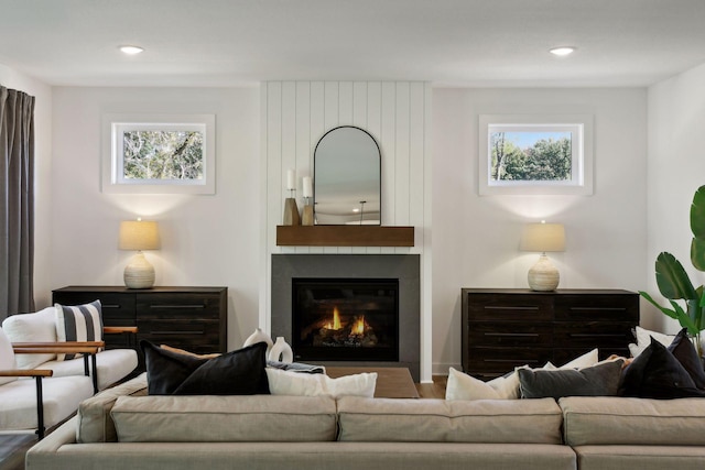 living room featuring recessed lighting, a large fireplace, and plenty of natural light