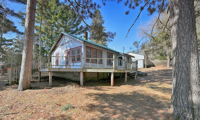 rear view of house with a deck and a chimney