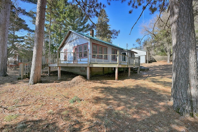 rear view of house featuring a deck and a chimney