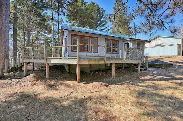 rear view of house featuring metal roof and a deck