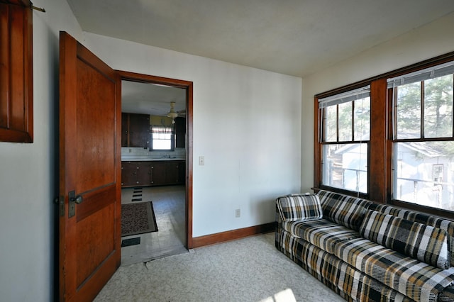 carpeted living area featuring baseboards