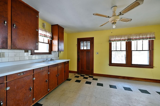 kitchen featuring backsplash, light floors, light countertops, and a ceiling fan