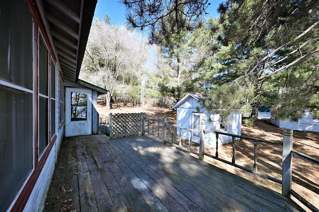 wooden deck featuring a storage shed and an outdoor structure