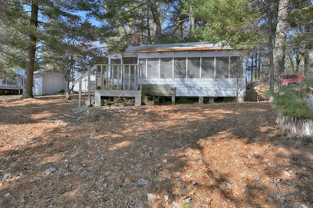 rear view of house with a chimney and a sunroom