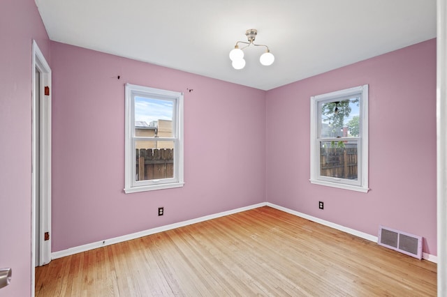5413 42nd Ave S, Minneapolis, MN 55417 - unfurnished room with light wood-style flooring, baseboards, and a chandelier