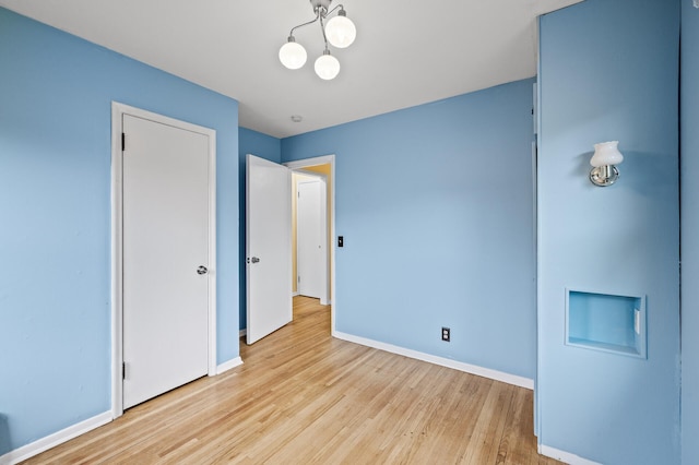 5413 42nd Ave S, Minneapolis, MN 55417 - unfurnished bedroom featuring wood finished floors, baseboards, and a chandelier