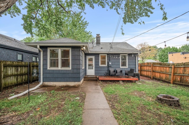 5413 42nd Ave S, Minneapolis, MN 55417 - rear view of house with an outdoor fire pit, a chimney, a deck, and a shingled roof