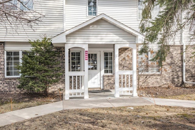 entrance to property featuring brick siding