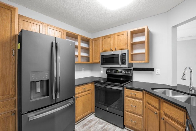 kitchen with refrigerator with ice dispenser, a sink, stainless steel microwave, dark countertops, and black / electric stove