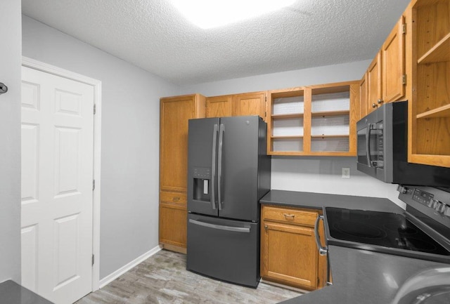 kitchen featuring open shelves, dark countertops, a textured ceiling, stainless steel appliances, and light wood-style floors