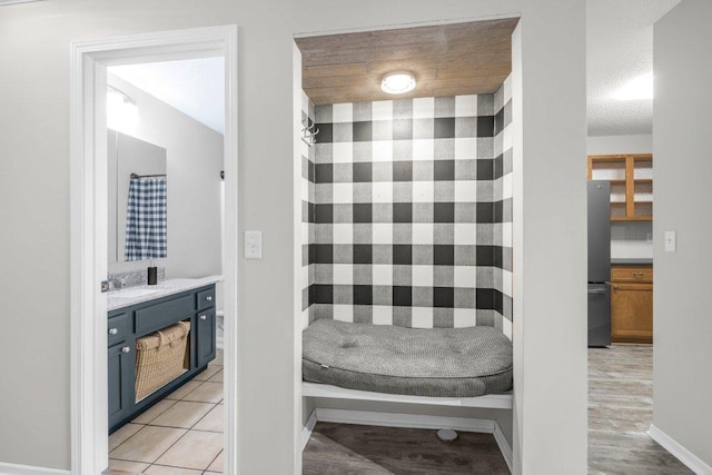 full bathroom with curtained shower, vanity, baseboards, and a textured ceiling